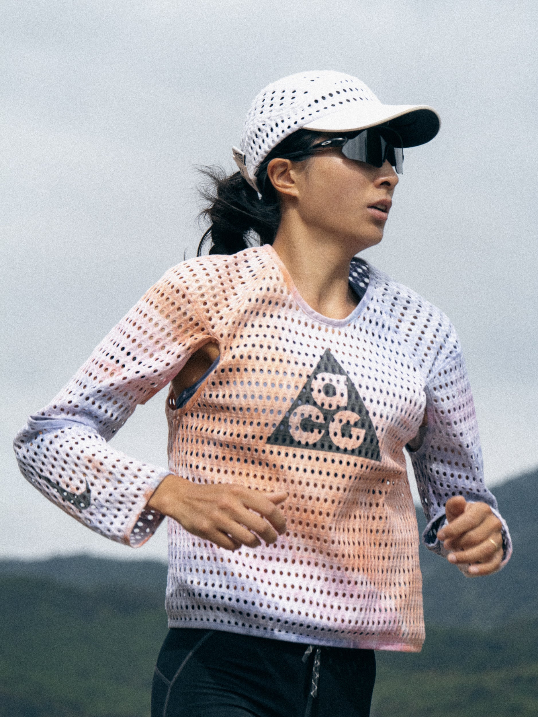 Yao Miao trail running in sunglasses and a white cap