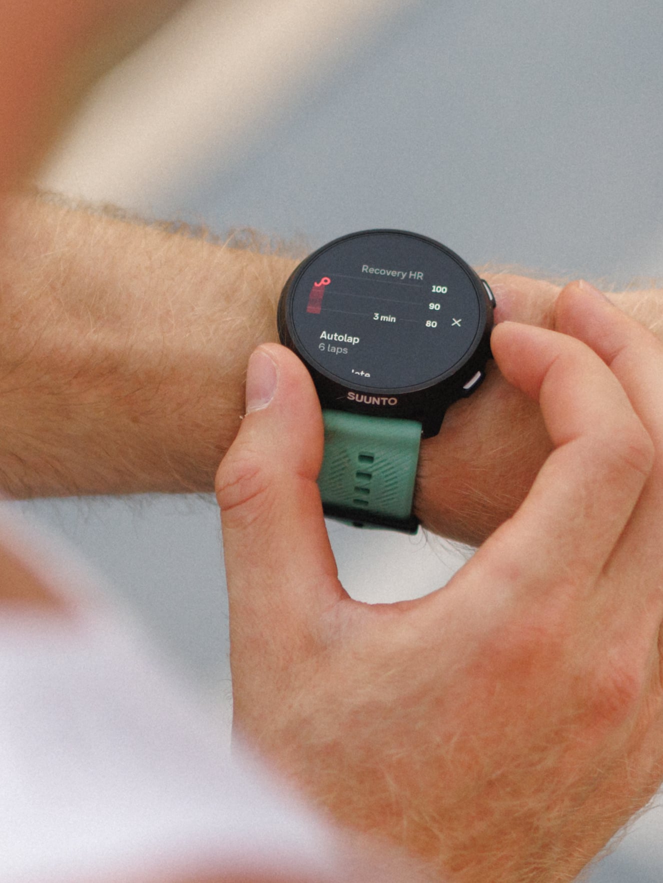 Close-up of a sports watch with a green strap on a runner