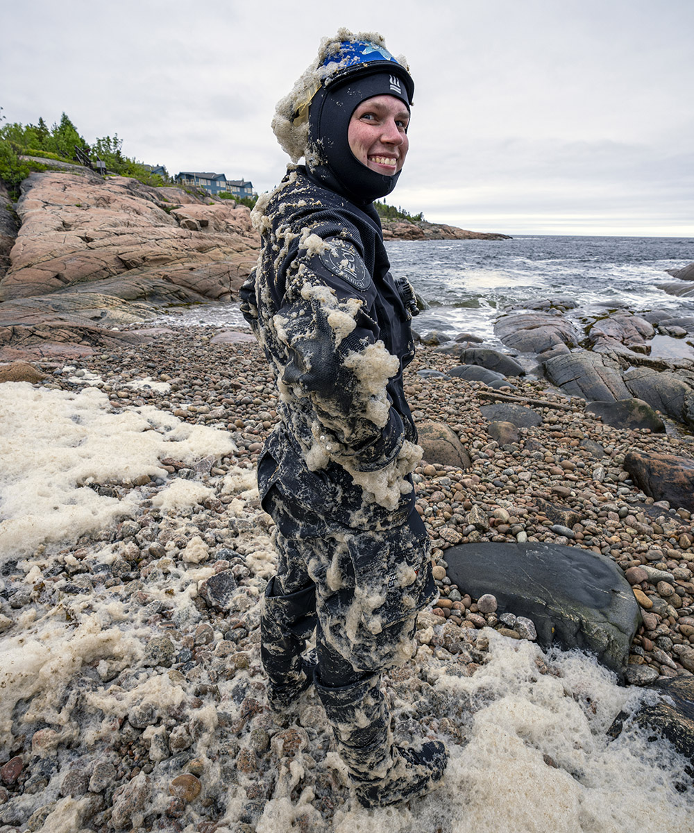 Kayla Martin playing in the sea foam in Les Escoumins.